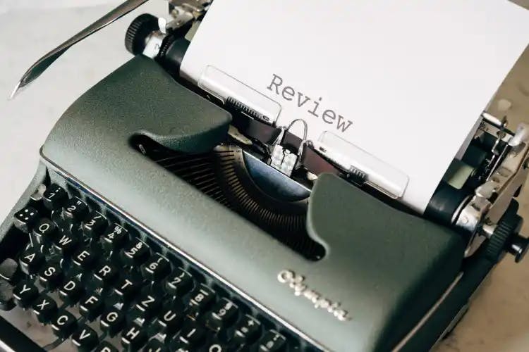 A typewriter with just the word Review typed on the page
